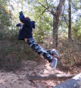 child leaping off a log